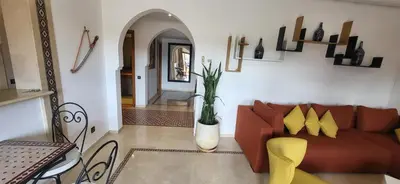 a living room with a red couch and yellow chairs at La Plaza cœur de Gueliz in Marrakech
