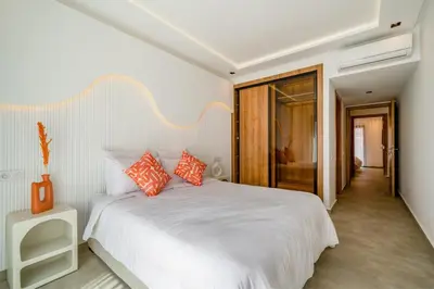 a bedroom with a white bed with orange pillows at Le Noria - Super logement Jardin & Piscine - Golf in Marrakech