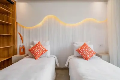 a bedroom with two beds with orange and white pillows at Le Noria - Super logement Jardin & Piscine - Golf in Marrakech
