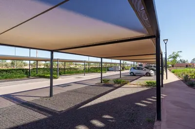 an empty parking lot with a car parked under a canopy at Le Noria - Super logement Jardin & Piscine - Golf in Marrakech