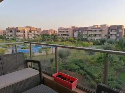 a balcony with a chair and a view of a city at Prestigious residence marrakech with optical fiber in Marrakech