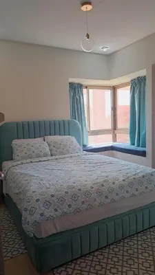 a bedroom with a blue bed with a window at Prestigious residence marrakech with optical fiber in Marrakech