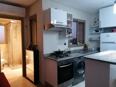 a kitchen with a stove and a washing machine at Prestigious residence marrakech with optical fiber in Marrakech