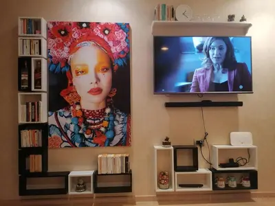 a flat screen tv on a wall with a painting of a woman at Prestigious residence marrakech with optical fiber in Marrakech