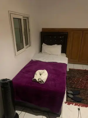 a bed with a purple blanket with a hat on it at Raid lkaram in Marrakech