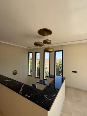 a kitchen with black marble counter top and windows at Villa Famous 4 chambres in Marrakech