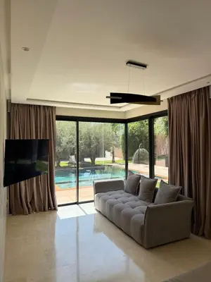 a living room with a couch and a large window at Villa Famous 4 chambres in Marrakech