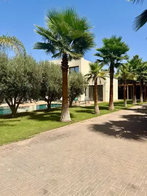 a road with palm trees and a building at Villa Famous 4 chambres in Marrakech