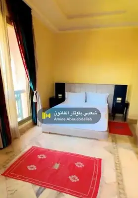 a bedroom with a bed with a red rug at Appartement La Palmeraie in Marrakech