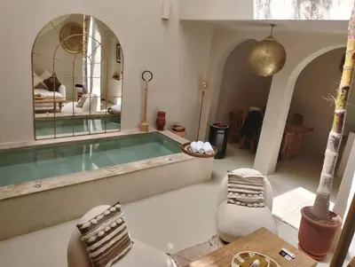 a large room with a swimming pool with a mirror at Riad Dar Sary Marrakech médina privé 3 chambres in Marrakech