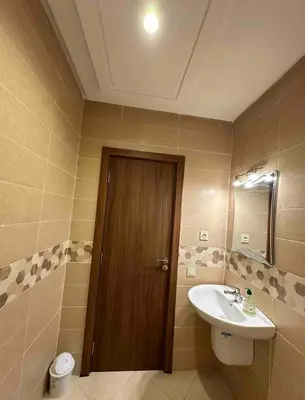 a bathroom with a sink and a toilet and a door at Appartement raffiné avec piscine au centre ville in Marrakech