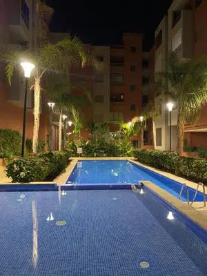 an empty swimming pool in a hotel at night at Appartement raffiné avec piscine au centre ville in Marrakech