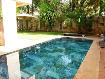 a swimming pool with blue water in a yard at Timeless Villa at Golf course with private pool in Marrakech