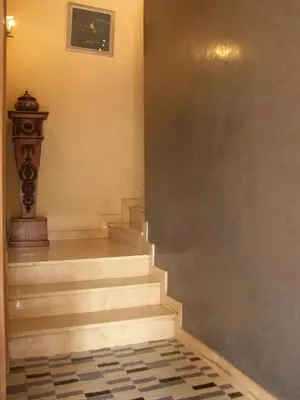 a hallway with stairs and a clock on the wall at Timeless Villa at Golf course with private pool in Marrakech