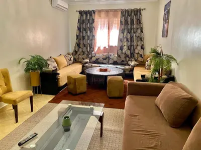 a living room with a couch and a table at Spacieux & confortable, parfait pour familles ou séjours tranquilles in Marrakech