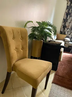 a yellow chair in a room with a potted plant at Spacieux & confortable, parfait pour familles ou séjours tranquilles in Marrakech