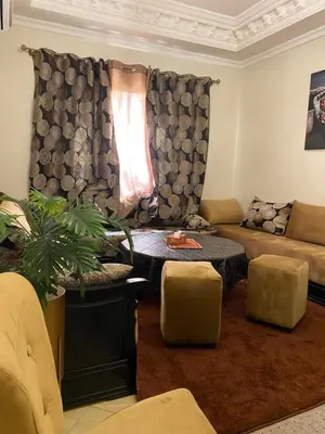a living room with a couch and a table at Spacieux & confortable, parfait pour familles ou séjours tranquilles in Marrakech