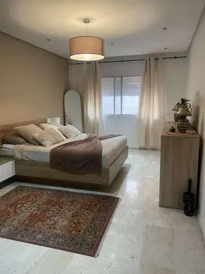 a bedroom with a large bed and a rug at Appartement ZAHRA HOME in Marrakech