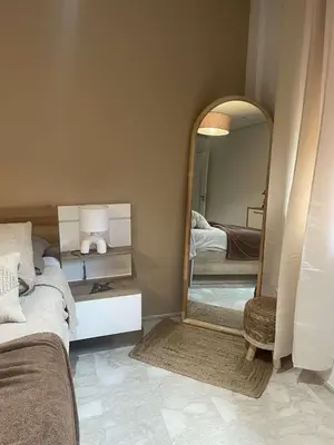 a bedroom with a bed and a large mirror at Appartement ZAHRA HOME in Marrakech