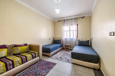 a room with two beds and a couch and a window at Modern and Convenient Apartment in Marrakech