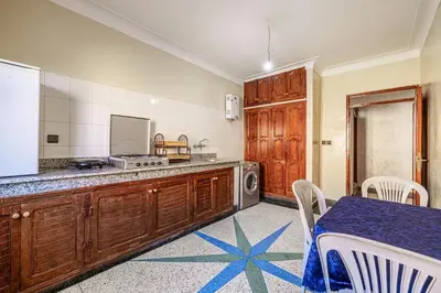 a kitchen with wooden cabinets and a table and a microwave at Modern and Convenient Apartment in Marrakech