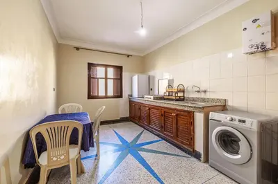 a kitchen with a table and a washing machine at Modern and Convenient Apartment in Marrakech