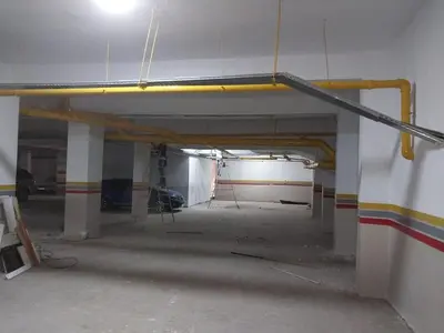 an empty parking garage with a yellow pipe on the wall at family apartment 8 in Marrakech