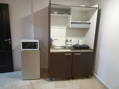 a small kitchen with a microwave and a sink at family apartment 8 in Marrakech