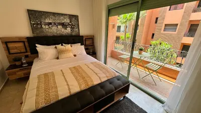 a bedroom with a large bed and a balcony at Modern apartment in City center in Marrakech