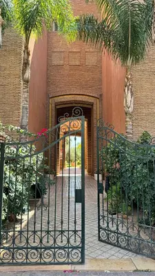 an entrance to a building with a gate and palm trees at Modern apartment in City center in Marrakech