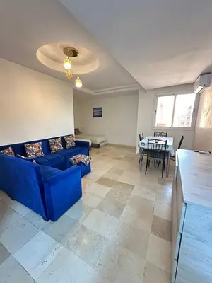 a living room with a blue couch and a table at Family apartment 22 in Marrakech