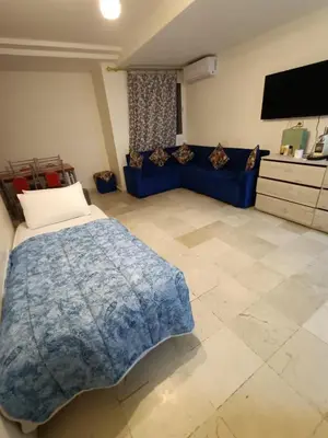 a living room with a blue bed and a couch at Family apartment 22 in Marrakech