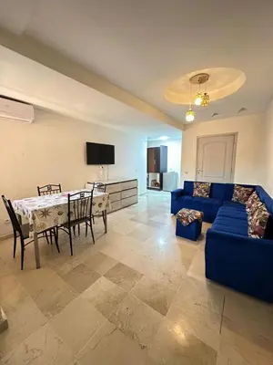 a living room with a blue couch and a table at Family apartment 22 in Marrakech