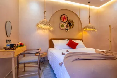 a bedroom with a bed and a table and a desk at ALKHAYMA Medina in Marrakech