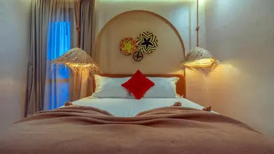 a bedroom with a bed with a red pillow at ALKHAYMA Medina in Marrakech