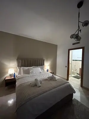 a bedroom with a large bed with towels on it at 2-bedroom luxury contemporary apartment Hivernage in Marrakech