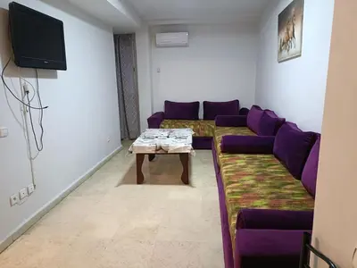 a living room with purple couches and a table at 30 family apartment in Marrakech