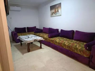 a living room with a purple couch and a table at 30 family apartment in Marrakech