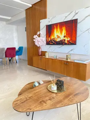 a living room with a fireplace and a table at Appartement cosy à Marrakech in Marrakech