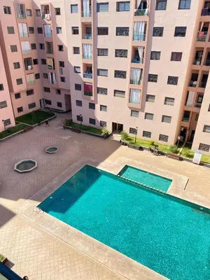 an empty swimming pool in front of a large building at Appartement cosy à Marrakech in Marrakech