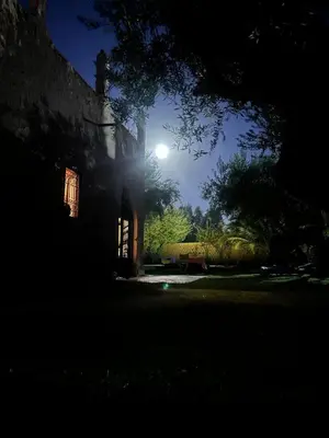 a building at night with the moon in the background at DAR TITRIT Charming house with garden and pool in Akhatar