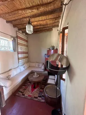a living room with a couch and a table at DAR TITRIT Charming house with garden and pool in Akhatar