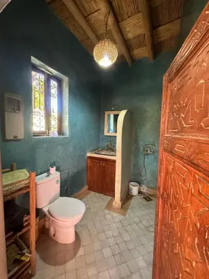 a bathroom with a toilet and a sink at DAR TITRIT Charming house with garden and pool in Akhatar