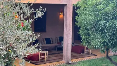 a patio with a table and chairs and trees at DAR EL KERMA Traditional Rustic House in Châba