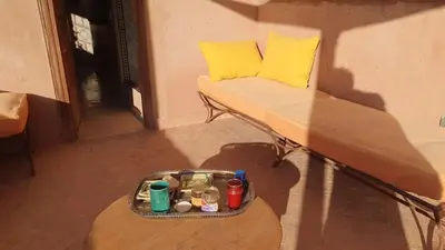 a couch with a tray of food sitting on a table at DAR EL KERMA Traditional Rustic House in Châba