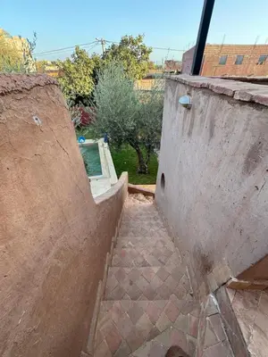 a stairway leading up to a building with a pool at DAR EL KERMA Traditional Rustic House in Châba