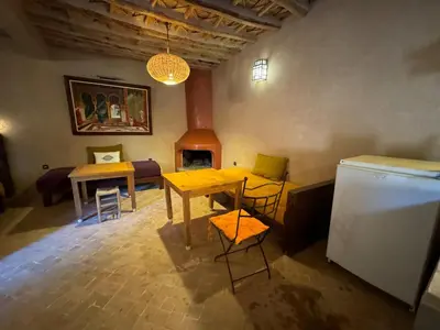a living room with a table and a refrigerator at DAR EL KERMA Traditional Rustic House in Châba