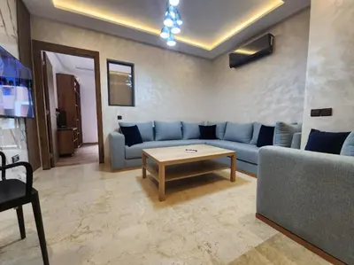 a living room with a blue couch and a coffee table at Charming Studio in Marrakech 2 min from the train station in Marrakech