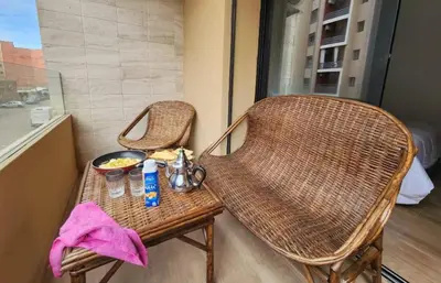 two wicker chairs and a table with a bowl of food at Charming Studio in Marrakech 2 min from the train station in Marrakech