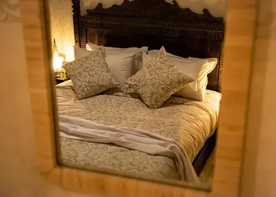 a reflection of a bed with pillows in a mirror at RIAD Dar ZOMOROD in Marrakech